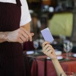 a customer handing a waiter a credit card